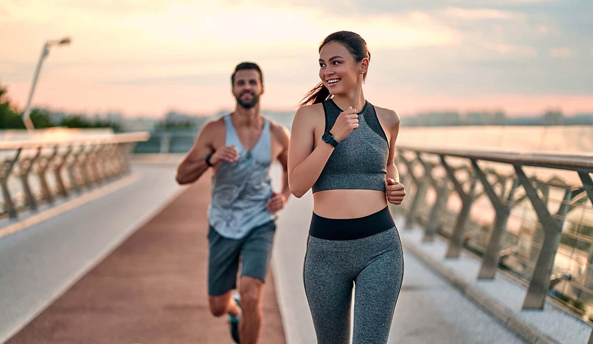 Two healthy people exercising outside in the morning.